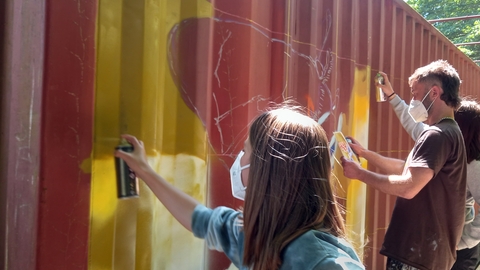 Close of young people spray painting 