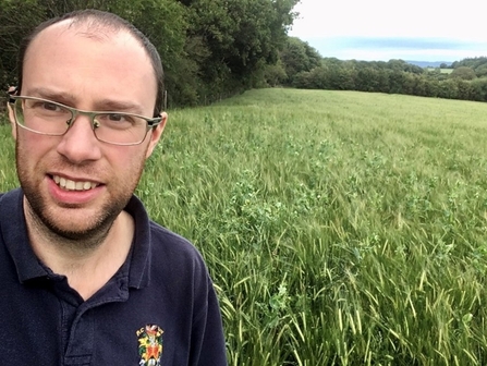 Owain Noble standing in farming field of grass