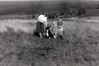 Old black and white picture of a family with their dog