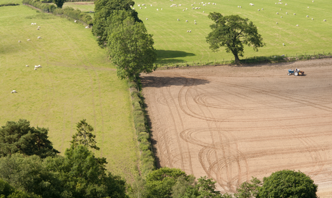 Agricultural scene with a field being farmed in the Welsh landscape