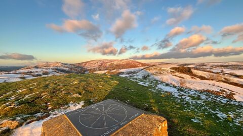 A view from the top of Roundton Hill, looking over the hills with light snow on them