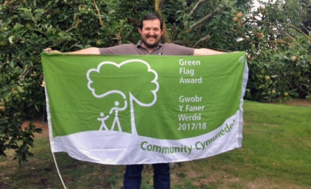 Warden of Severn Farm Pond holding the Green Flag Award flag
