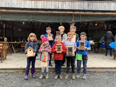 Children holding their wildlife boxes they have constructed as part of the Learn and Build project at Camp Plas