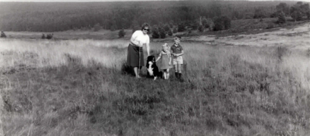 Old black and white picture of a family with their dog
