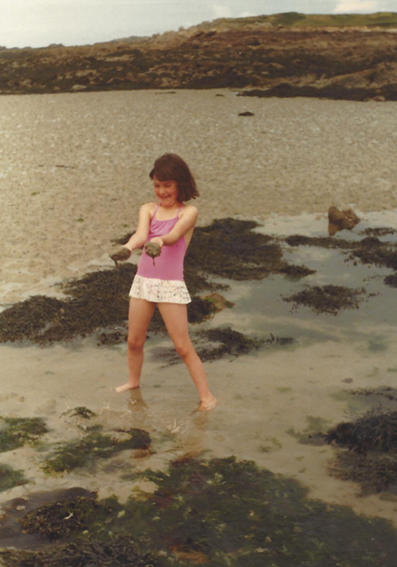 Little girl on a beach playing in the rockpools