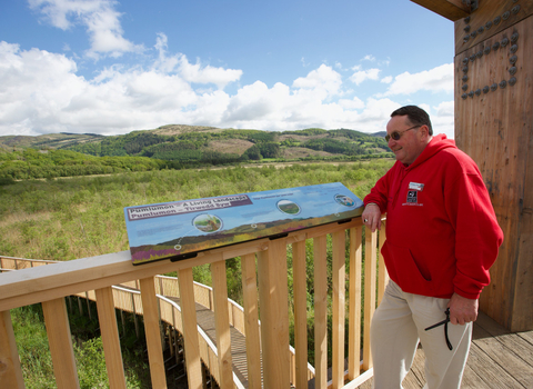 Posh Pete (Morgan) standing by Pumlumon interpretation overlooking Cors Dyfi Nature Reserve