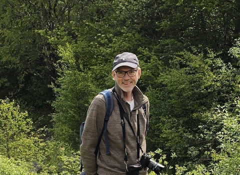 Tim Ward, MWT Trustee, standing outside with his binoculars