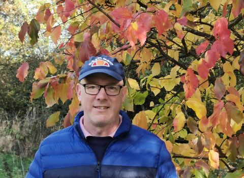 Headshot of Berni McEwan in front of autumn leaves