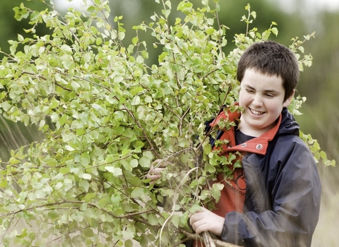 Boy collecting saplings at Westhay, Somerset, to maintain wetland habitat copyright Ross Hoddinott/2020VISION